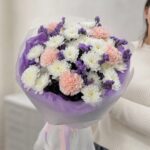 Букет с белыми хризантемами, розовыми гвоздиками и сиреневой статицей в упаковке